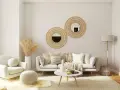 Salón acogedor con butaca blanca y sofá gris, decorado con espejos de mimbre y plantas secas. La combinación de sofá y butaca crea un espacio perfecto para relajarse.