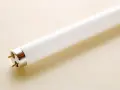Tubo fluorescente con dos pines dorados, listo para cambiar por led y ahorrar energía.