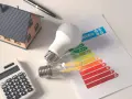 Casa modelo, bombillas, calculadora y etiqueta de eficiencia energética. Planifica la eficiencia energética de tu hogar.