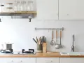 Diseños de cocinas pequeñas y sencillas: encimera de madera, campana extractora, utensilios colgados y un fregadero blanco.