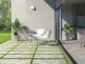 Modernos suelos para patios interiores con un diseño de baldosas y césped. Un espacio acogedor con mesa y sillas blancas.