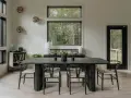 Elegante mesa negra y sillas de diseño para una perfecta decoracion comedores modernos. Ventanales con vistas al bosque.