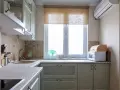 Cortinas de cocina de bambú sobre ventana, con microondas y panera de madera.