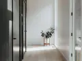 Ideas para como decorar un recibidor pequeño: una planta en maceta blanca sobre un soporte de madera ilumina el pasillo.