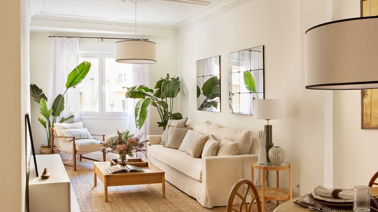 Elegante decoracion salon con sofá beige, plantas verdes, mesa de centro de madera y sillón.