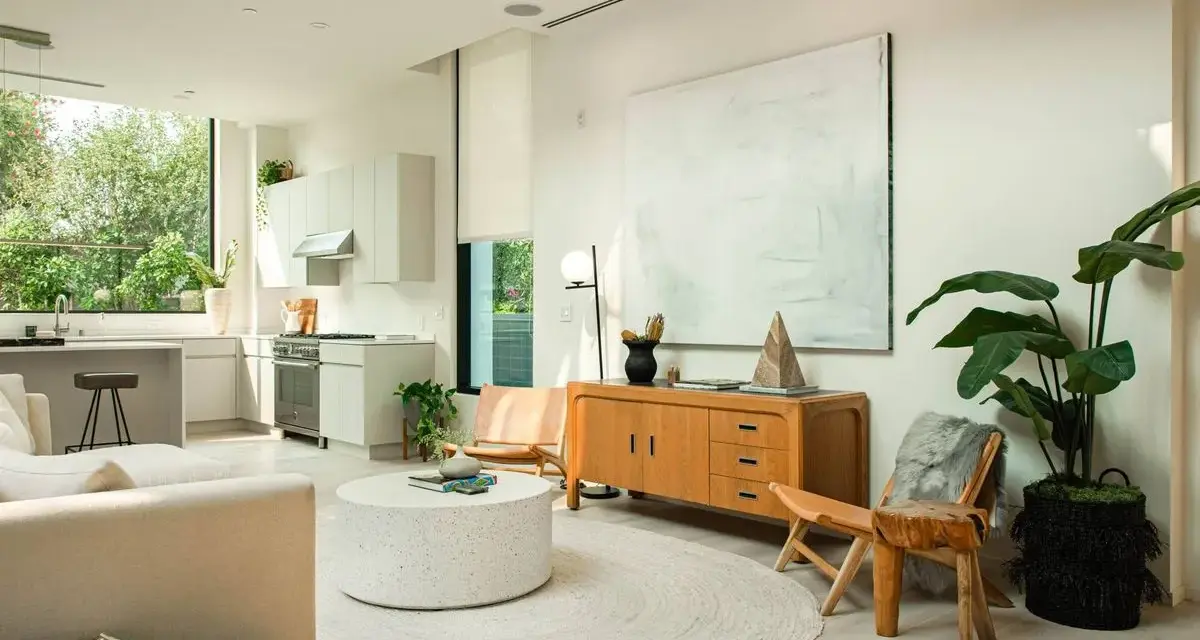 Un salón luminoso con cocina integrada, muebles de madera clara y decoración minimalista, reflejando un estilo nordico casa.