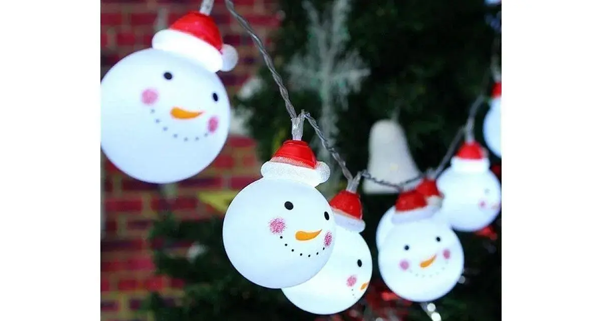 Luces de muñecos de nieve con gorros rojos, perfectos adornos navideños caseros para exterior, iluminan la noche festiva.