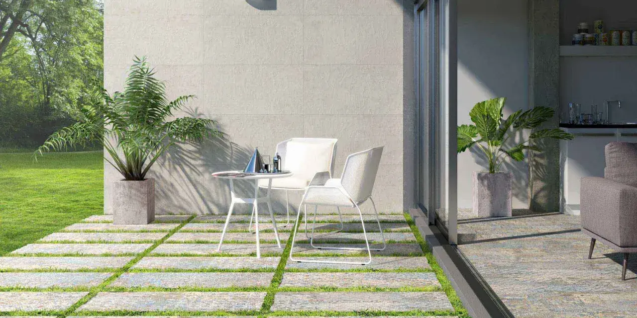 Modernos suelos para patios interiores con un diseño de baldosas y césped. Un espacio acogedor con mesa y sillas blancas.