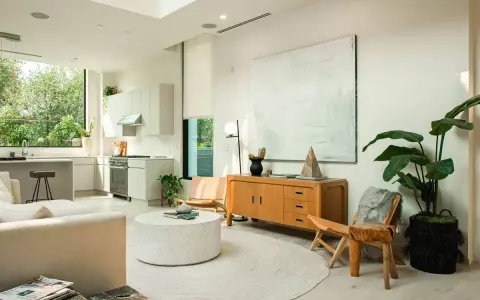 Un salón luminoso con cocina integrada, muebles de madera clara y decoración minimalista, reflejando un estilo nordico casa.