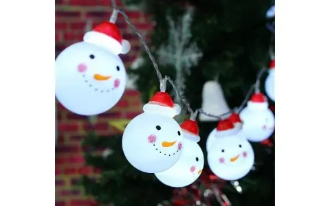 Luces de muñecos de nieve con gorros rojos, perfectos adornos navideños caseros para exterior, iluminan la noche festiva.