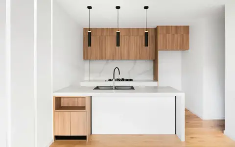 Cocinas pequeñas con barra, minimalistas y modernas, con gabinetes de madera y encimera blanca.