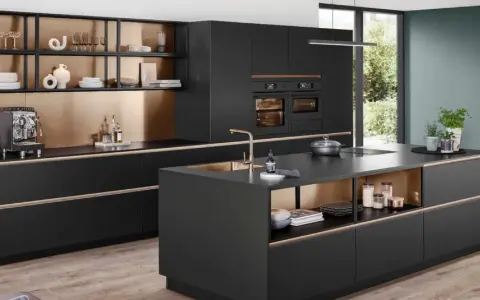 Elegantes cocinas pequeñas con isla central negra, gabinetes dorados y electrodomésticos integrados.