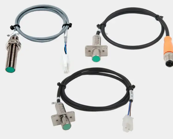 Tres sensores de proximidad con cables y conectores, parte de un esquema detector de presencia.