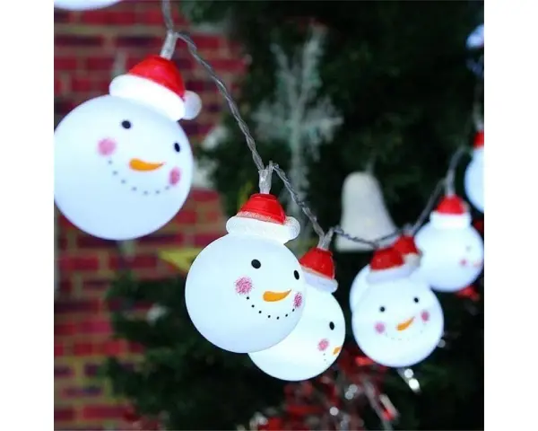 Luces de muñecos de nieve con gorros rojos, perfectos adornos navideños caseros para exterior, iluminan la noche festiva.