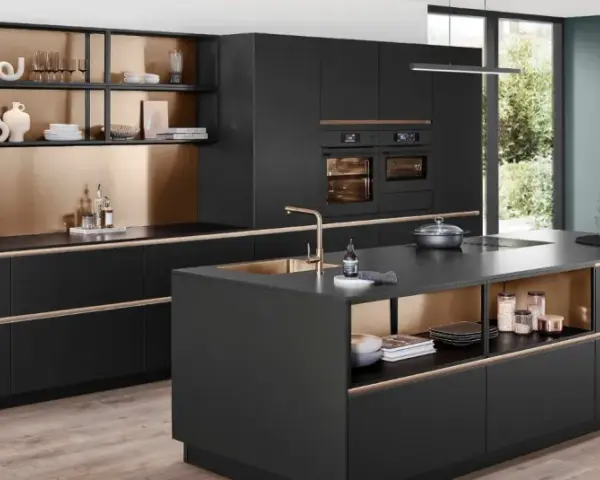 Elegantes cocinas pequeñas con isla central negra, gabinetes dorados y electrodomésticos integrados.