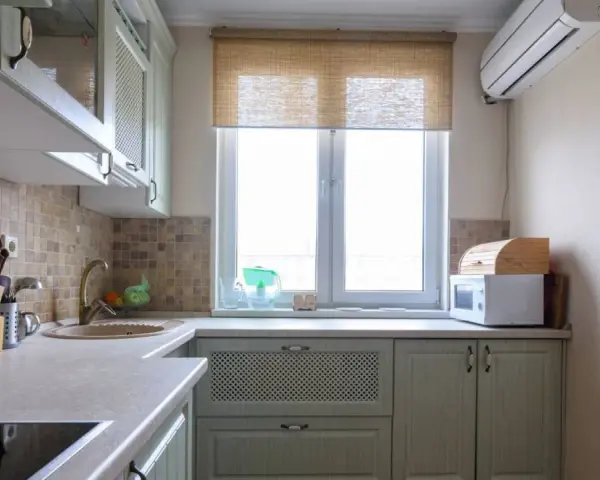 Cortinas de cocina de bambú sobre ventana, con microondas y panera de madera.