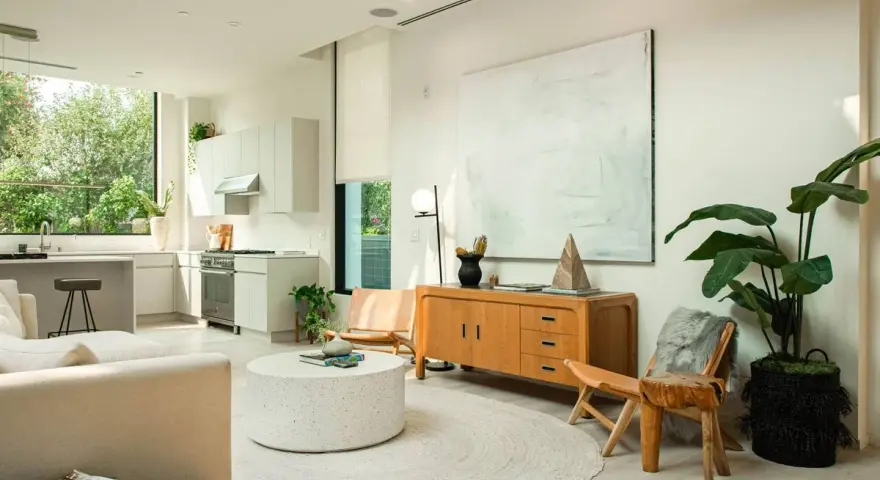 Un salón luminoso con cocina integrada, muebles de madera clara y decoración minimalista, reflejando un estilo nordico casa.