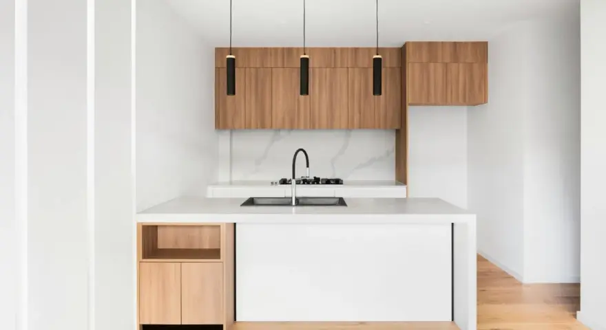 Cocinas pequeñas con barra, minimalistas y modernas, con gabinetes de madera y encimera blanca.