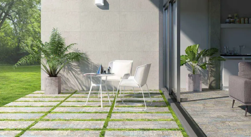 Modernos suelos para patios interiores con un diseño de baldosas y césped. Un espacio acogedor con mesa y sillas blancas.