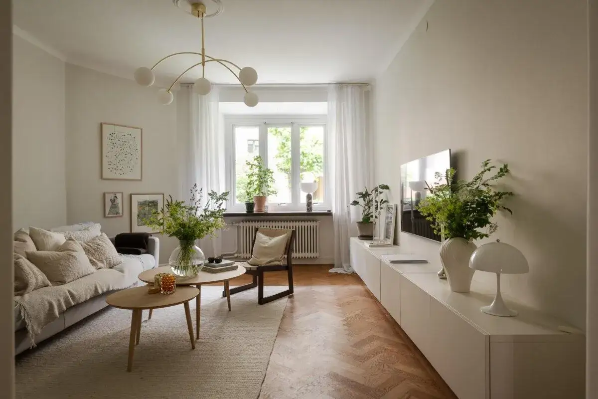 Salón acogedor con sofá beige, mesas de centro de madera y plantas, en un estilo nórdico casa.