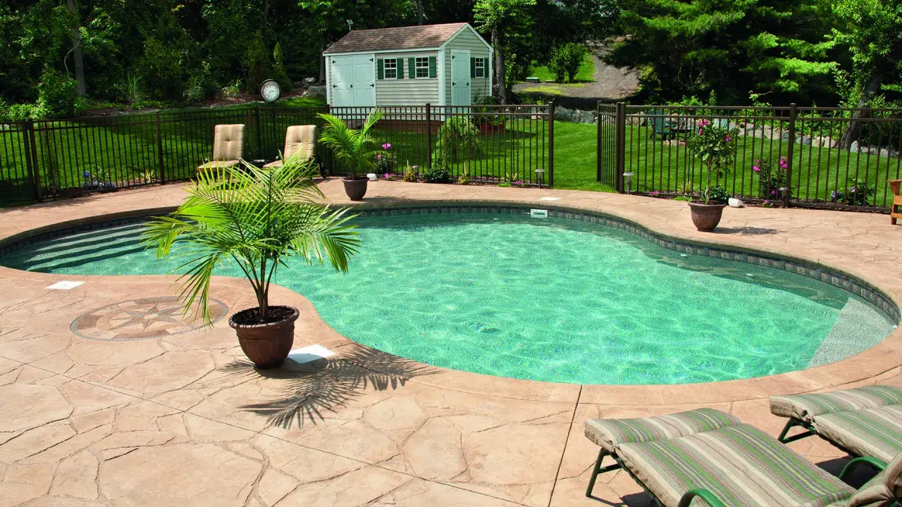 Piscina de obra con agua cristalina, rodeada de un patio de piedra y tumbonas. Ideal para relajarse. ¿Cuánto cuesta una piscina de obra?