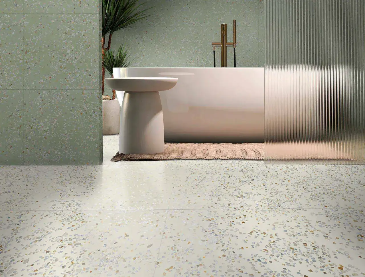 Un ba&ntilde;o moderno con suelo de terrazo y paredes a juego. Una ba&ntilde;era blanca y un grifo dorado destacan en el dise&ntilde;o.