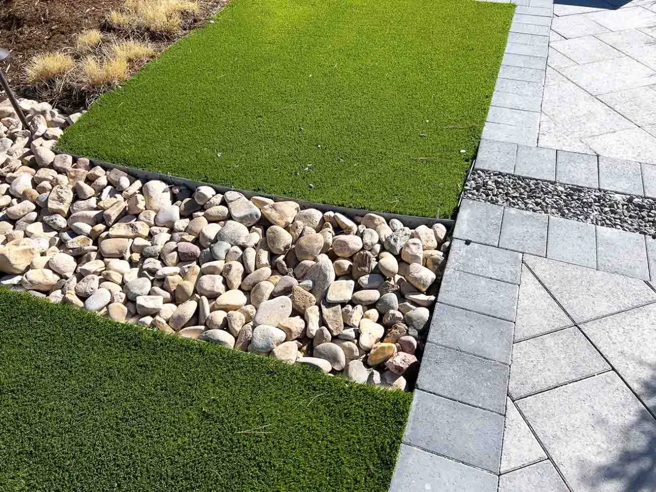 Diseño de jardín moderno con césped artificial y rocas. Ideales suelos para jardín sin obra, creando un espacio atractivo y de bajo mantenimiento.
