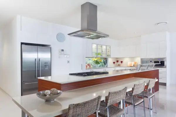 Cocina moderna con isla, electrodomésticos de acero inoxidable y encimera de cuarzo. Ideal para calcular el reforma cocina precio aproximado.